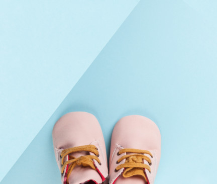 dětské růžové botičky na modrém pozadí