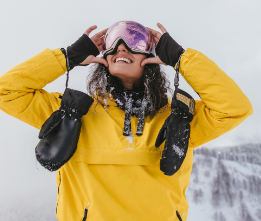 Žena ve žluté lyžařské bundě s palčáky